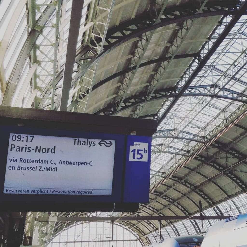 a platform sign at Amsterdam Centraal station showing the next Thalys to Paris-Nord at 09:17