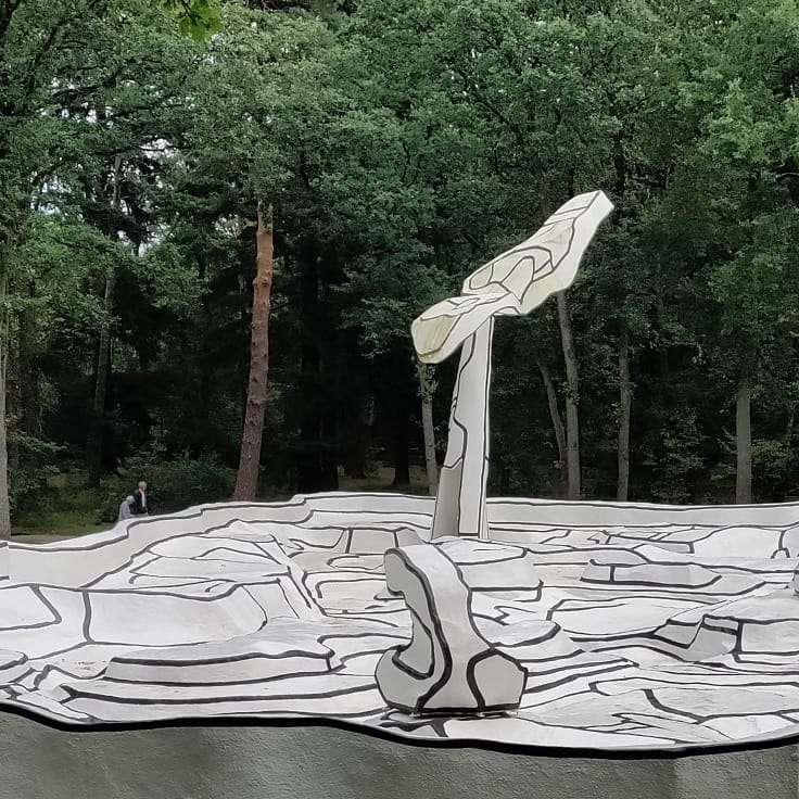 a black and white sculpture set in a park