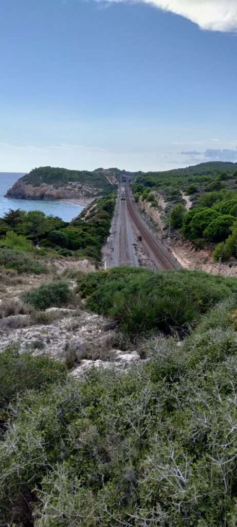 A view of the rail track with Platja de l'Home Mort